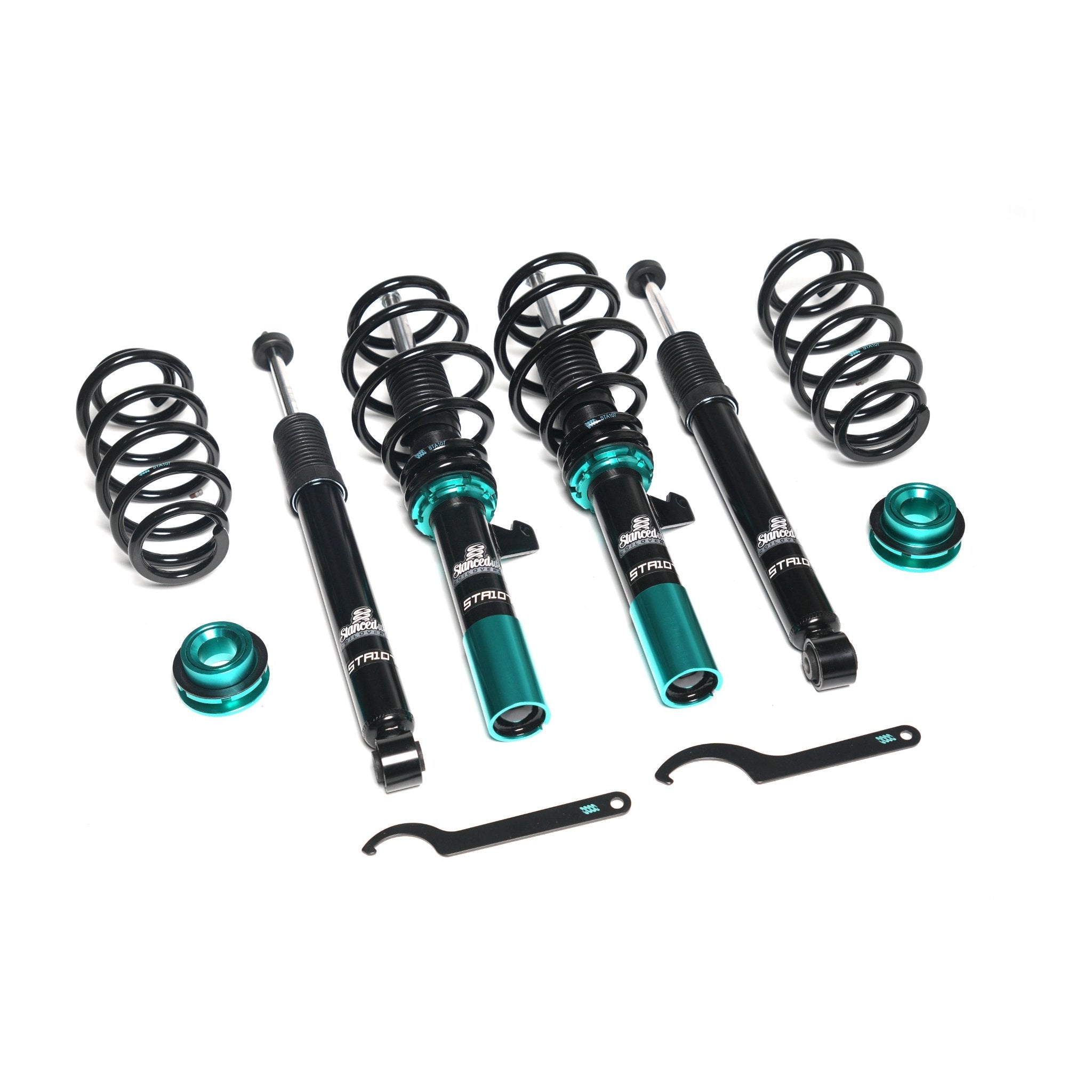 Top-down view of Stanced UK STA106 coilover kit laid out with spanners, springs, shocks, and components