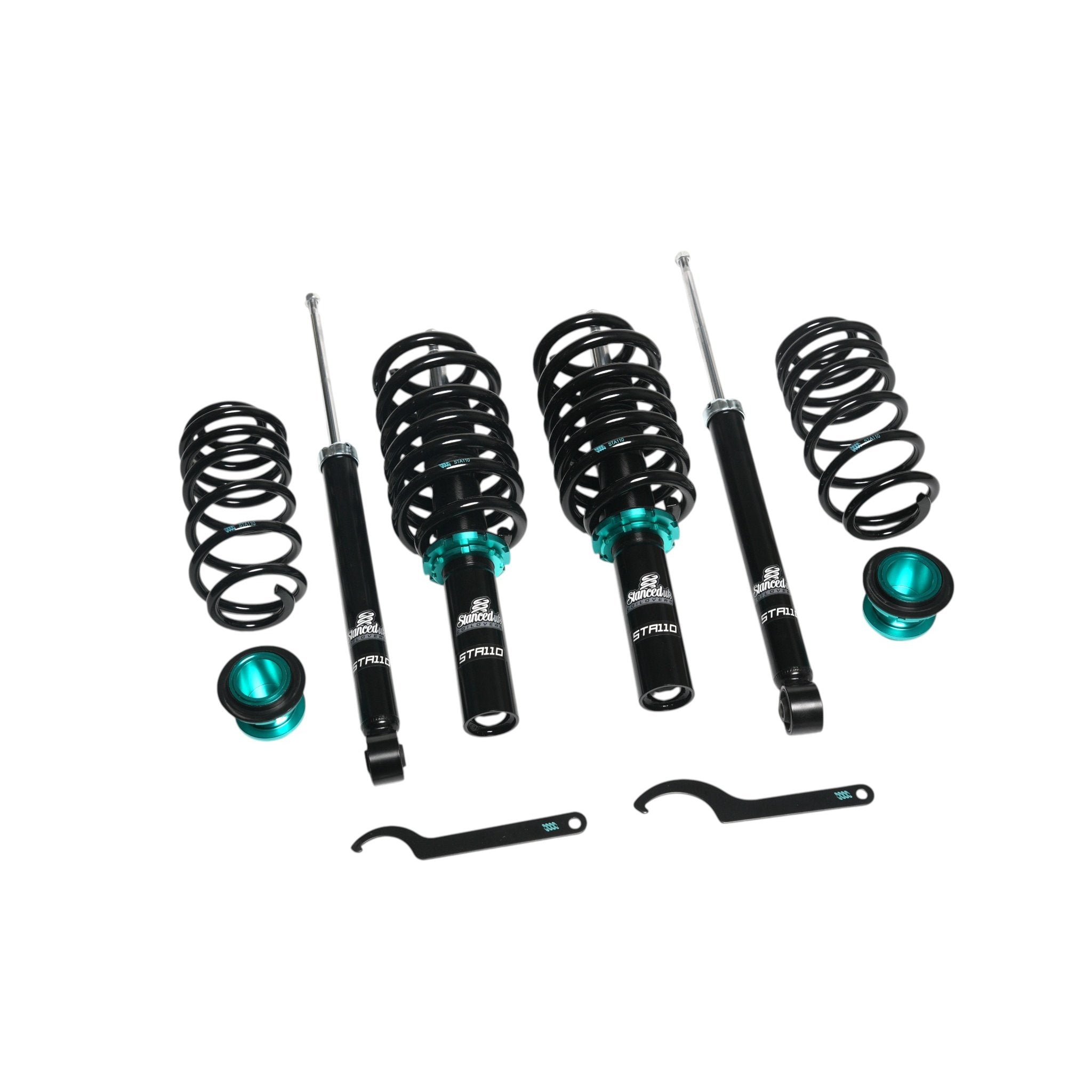 Stanced UK STA110 coilover kit laid out showing front and rear components – shocks, springs, perches and tools
